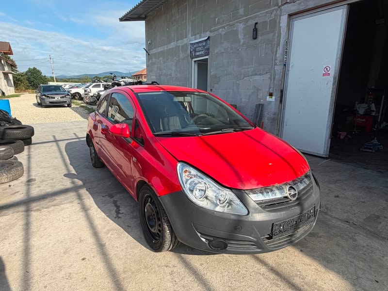 Opel Corsa roșu fotografiat în parcul de dezmembrări din Novaci